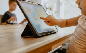 Família planejando viagem em dispositivo digital, integrando trabalho remoto, lazer e cuidados infantis em um roteiro único e inteligente.
